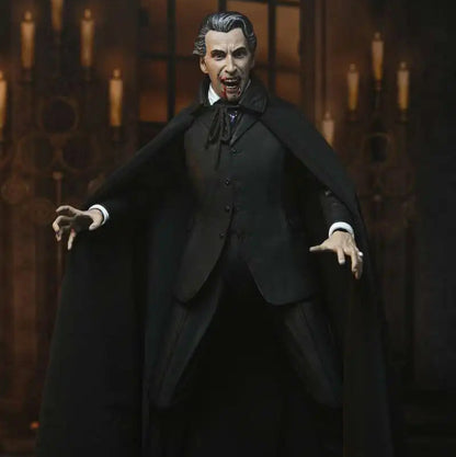 Action figure of a character in a dark suit and cape against a gothic-style background with candles.