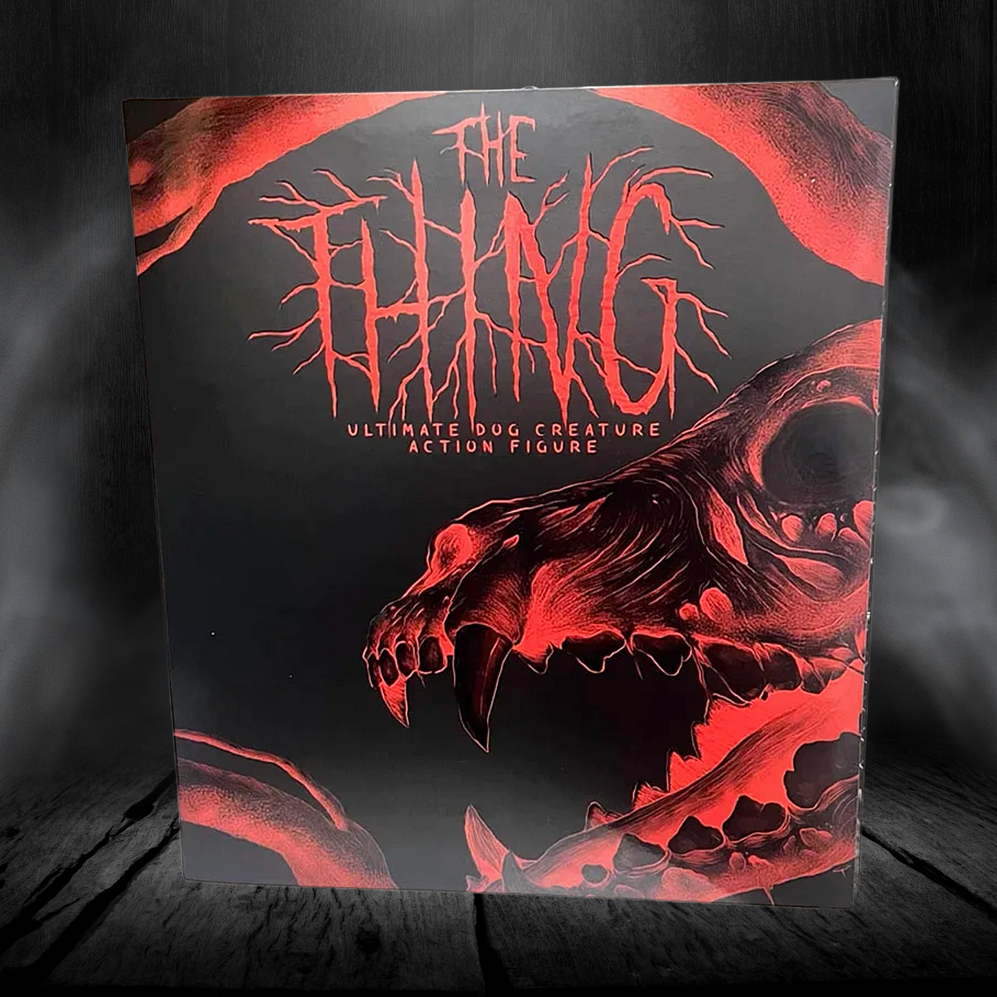 Action figure packaging with red and black design on a dark background