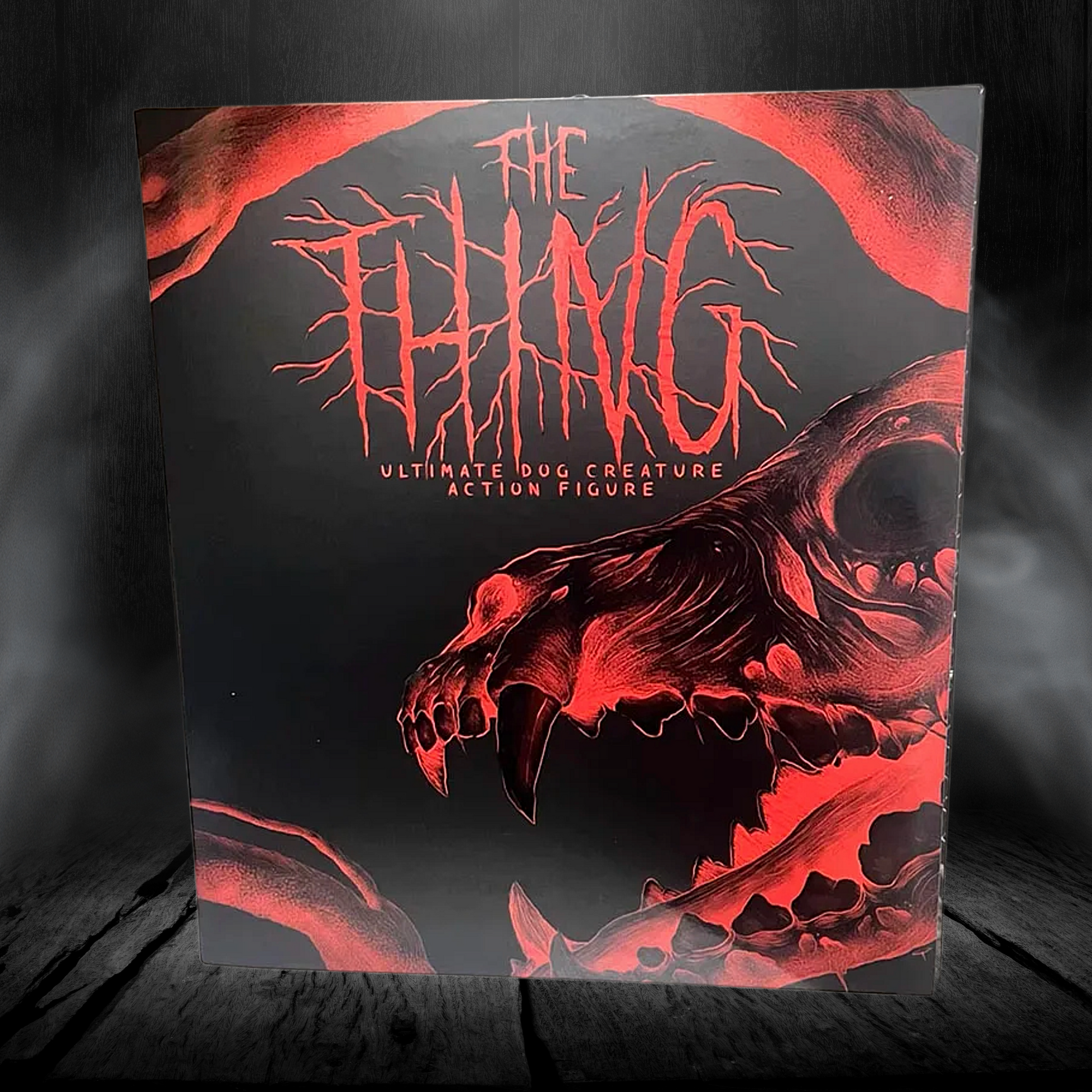 Action figure packaging with red and black design on a dark background